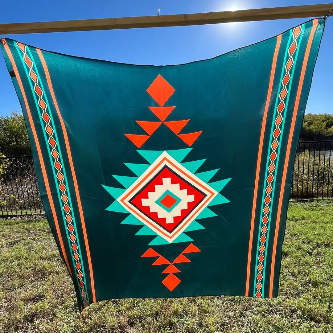 Blue bandana silk scarf with large print of cream, red, turquoise and adobe orange.