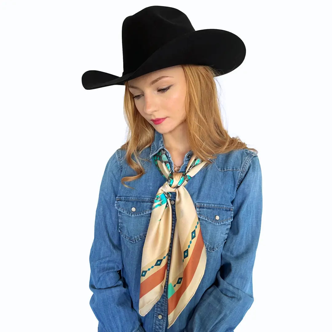 Cowgirl is wearing a soft tan and turquoise design silk scarf wild rag.