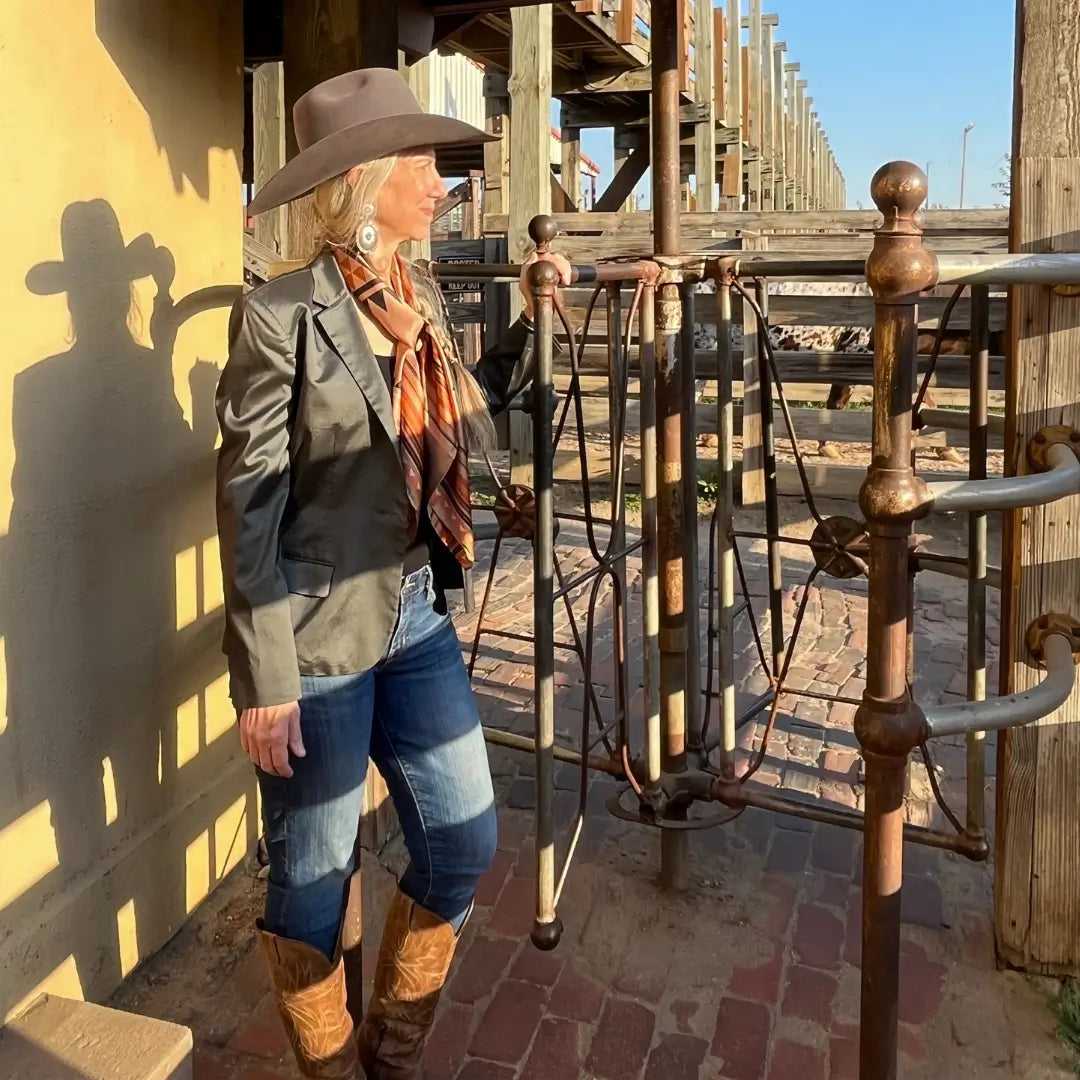 Cowgirl is wearing a southwestern soft brown and copper silk scarf wild rag in the Fort Worth Stockyards. 