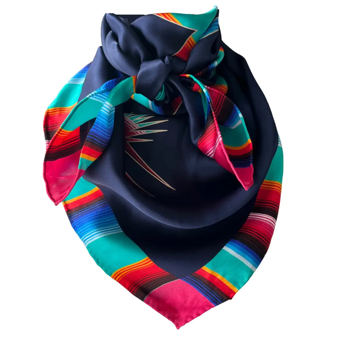 Cowtown Wild Rags Aztec silk scarf with navy blue and a serape design of a cowgirl and horse.