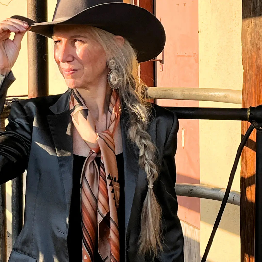 Cowgirl is wearing a southwestern soft brown and copper silk scarf wild rag in the Fort Worth Stockyards. 