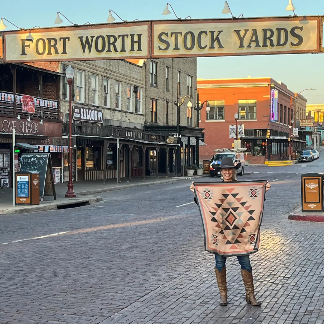 Cowgirl wearing Cowtown Wild Rags Aztec silk scarf with dusty pink, charcoal and soft gray in the Fort Worth Stockyards.