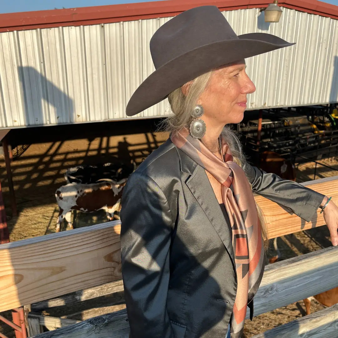 Cowgirl wearing Cowtown Wild Rags Aztec silk scarf with dusty pink, charcoal and soft gray in the Fort Worth Stockyards.