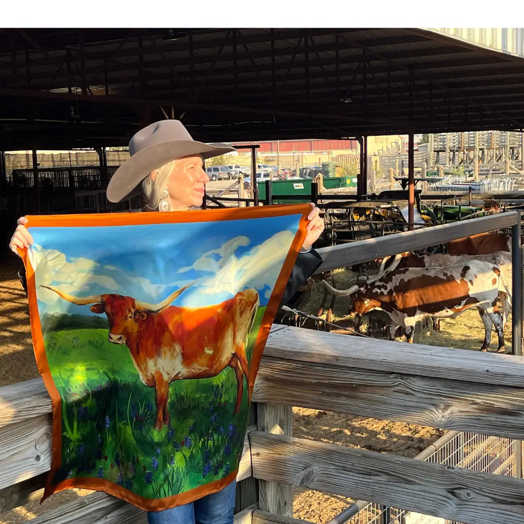 Cowgirl holding a longhorn silk scarf wild rag in the Fort Worth Stockyards.