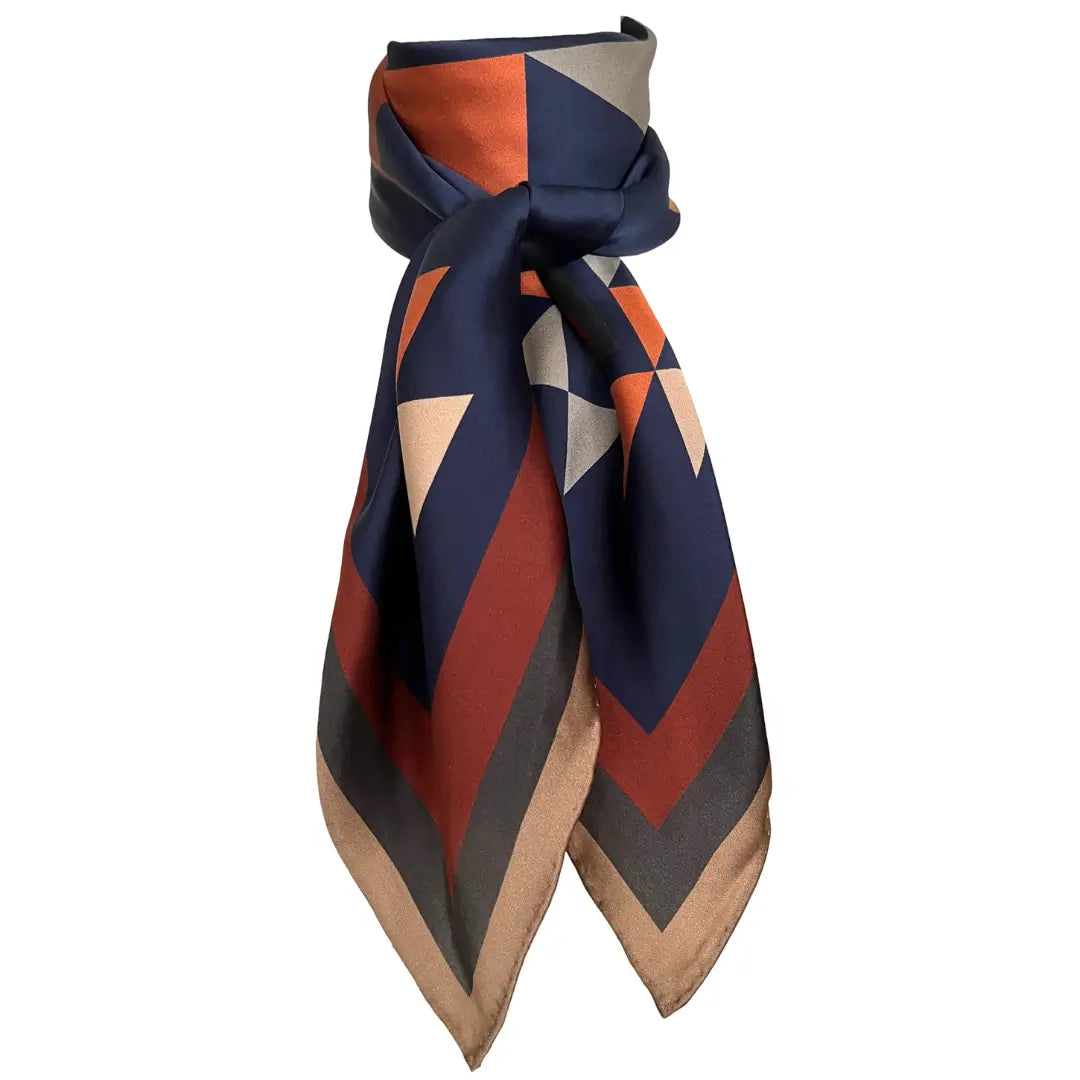 Close-up of Cowtown Wild Rags with a large Aztec silk scarf with navy blue, soft tan, copper, and charcoal gray.