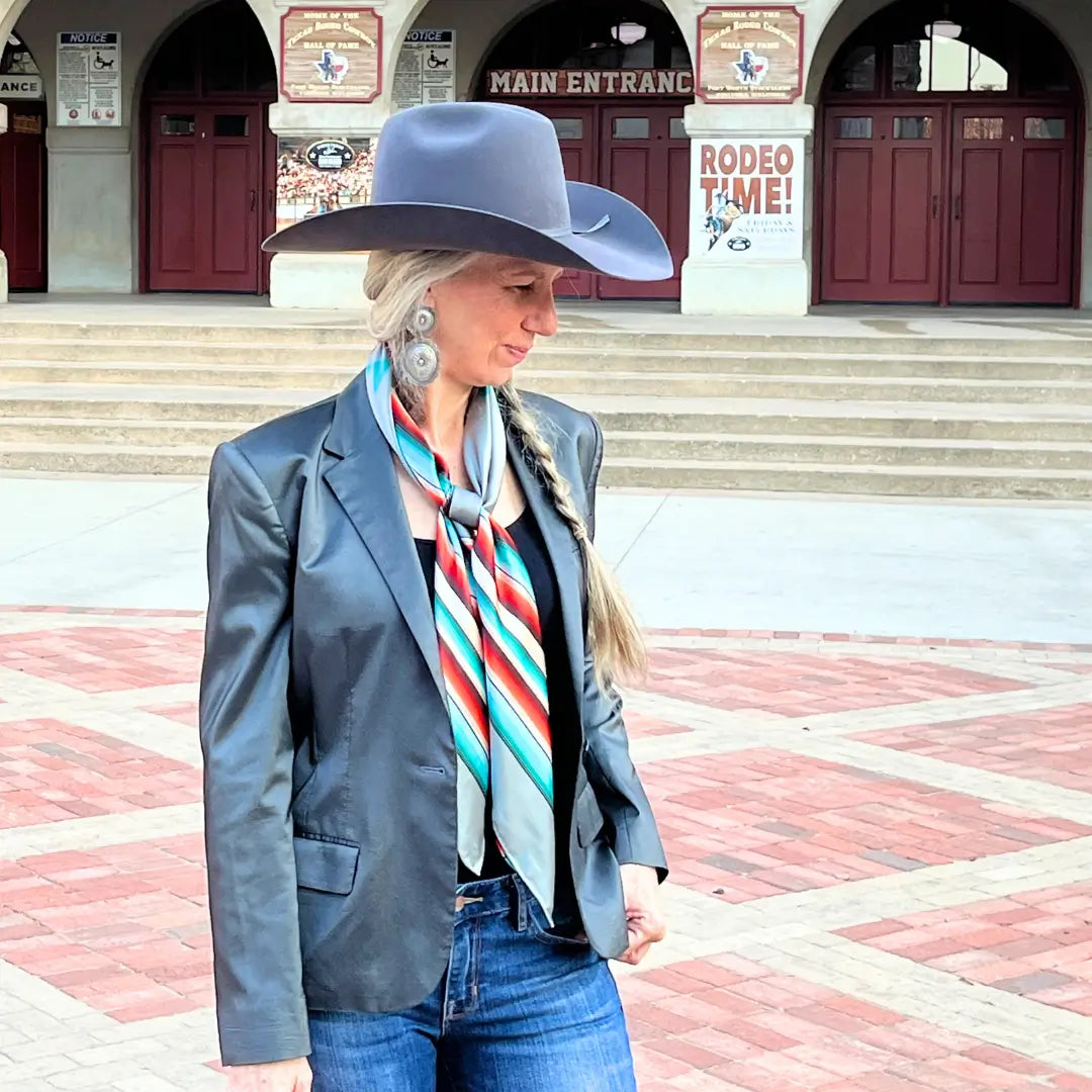 Cowgirl wearing a Cowtown Wild Rags gray serape silk scarf with turquoise, maroon, and coral in the Fort Worth Stockyards.