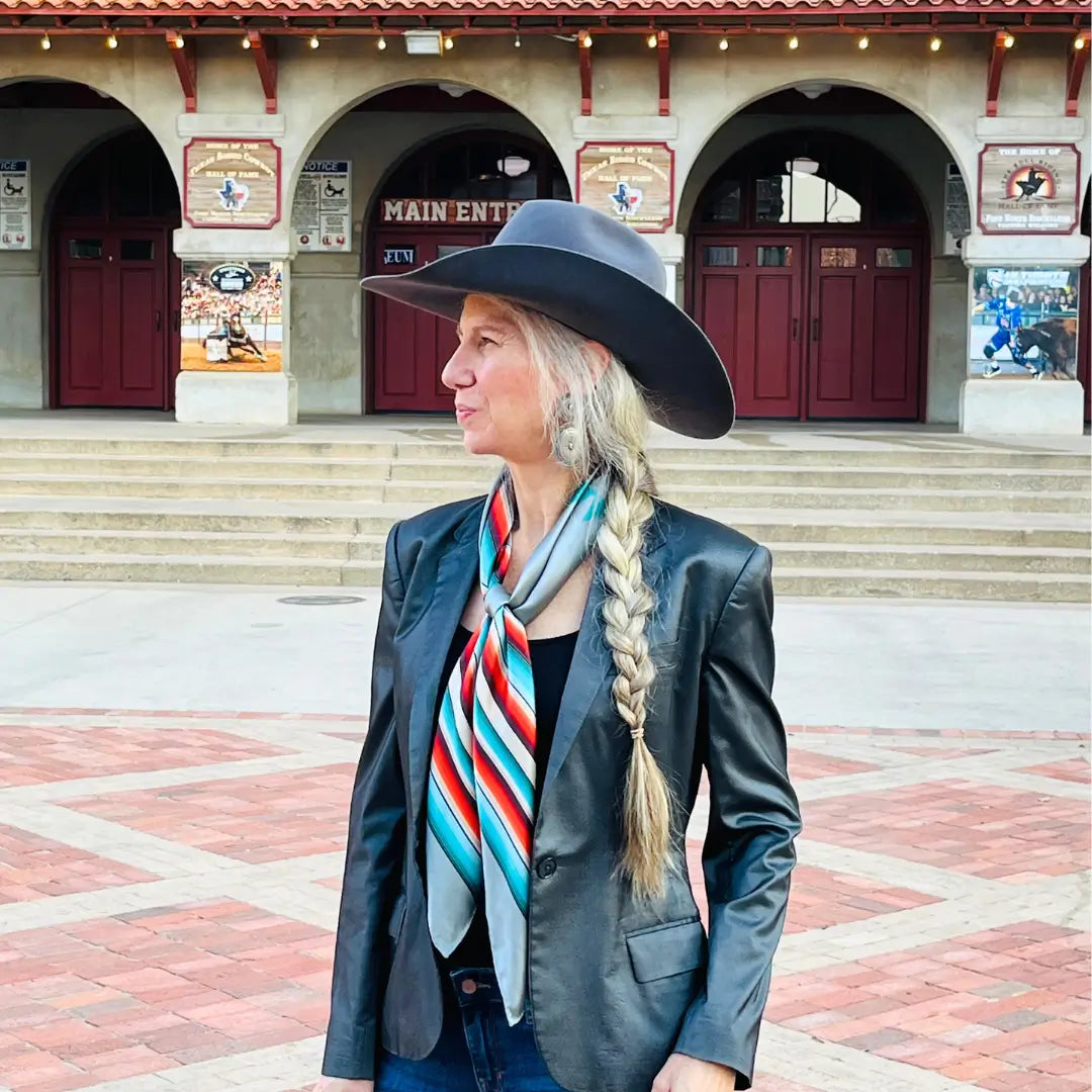 Cowgirl wearing a Cowtown Wild Rags gray serape silk scarf with turquoise, maroon, and coral.