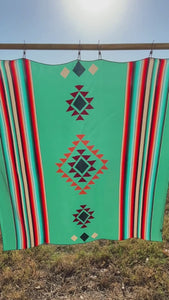 Video of a Cowtown Wild Rags turquoise serape silk scarf with tan, maroon, and coral.