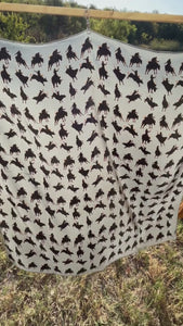 Video of black silhouette bull riders / bull riding outlined in tan on a gray silk scarf wild rag.